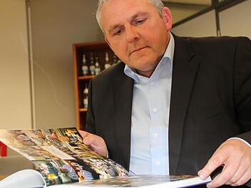 Vorstandsvorsitzender Ingo Vialon blättert durch die Chronik der Staatlichen Mineralbrunnen AG. Foto: Ulrike Müller