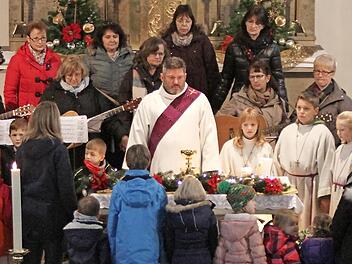 Die Buben und Mädchen begaben sich mit dem Kinderkirchen-Team, der Singgruppe und mit Diakon Joachim Stapf an die Krippe, die am Altar der Matthäus-Kirche in Breitbrunn aufgebaut ist.  Foto: Günther Geiling