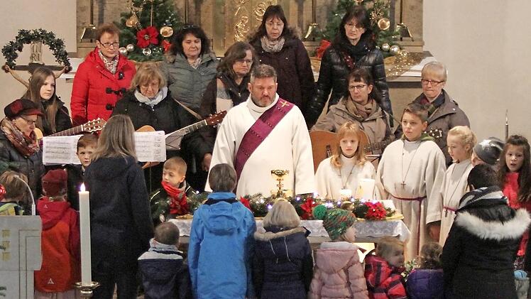 Die Buben und Mädchen begaben sich mit dem Kinderkirchen-Team, der Singgruppe und mit Diakon Joachim Stapf an die Krippe, die am Altar der Matthäus-Kirche in Breitbrunn aufgebaut ist.  Foto: Günther Geiling