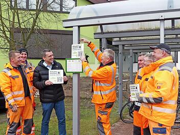 Nicht nur an Bushaltestellen wie hier, sondern auch an Straßenlaternen werden Röttenbacher Bauhofmitarbeiter die Schilder anbringen, damit Bürger Schäden schnell per Handy melden können. Bürgermeister Ludwig Wahl (Dritter von links) freut sich, diesen Service anbieten zu können.  Foto: Pauline Lindner