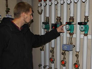 Jürgen Ramming vor den sauber installierten Heizungsrohren im Anwesen Thaler. Einen Energiespartipp hat er sofort parat: Die älteren Umwälzpumpen (rechts von seiner Hand) gegen Effizienzpumpen (eine ist links von seiner Hand) austauschen. Diese Investition hat sich in zwei bis drei Jahren amortisiert. Fotos: Schedel