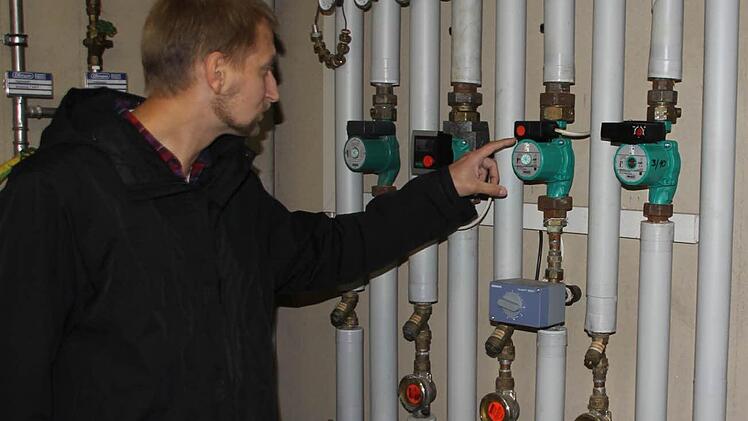 Jürgen Ramming vor den sauber installierten Heizungsrohren im Anwesen Thaler. Einen Energiespartipp hat er sofort parat: Die älteren Umwälzpumpen (rechts von seiner Hand) gegen Effizienzpumpen (eine ist links von seiner Hand) austauschen. Diese Investition hat sich in zwei bis drei Jahren amortisiert. Fotos: Schedel