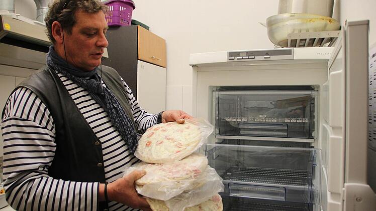 Claus Poppe sortiert Tiefkühlpizzen in den neuen Gefrierschrank ein. Foto: Benedikt Borst