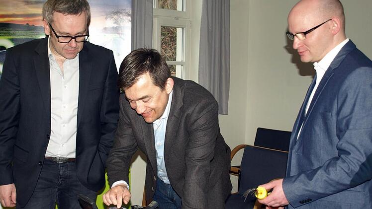 Bürgermeister Jens Korn (Mitte) versuchte sich unter Anleitung des Thüga-Geschäftsführers Peter Horn (links) in der Handhabung eines Spleißgerätes, das Glasfasern verbinden kann.  Foto: Susanne Deuerling