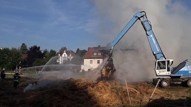 Scheunenbrand auf Bauernhof in Heilsbronn: Ein Bagger legt nach dem gro&szlig;en Feuer Glutnester frei. Foto: NEWS5 / Fechner