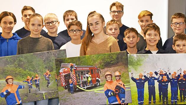 Die Jugendlichen der Wehren Rothenkirchen und Geh&uuml;lz pr&auml;sentieren die drei sch&ouml;nsten Bilder des Wettbewerbs.  Foto: Matthias Schuhb&auml;ck