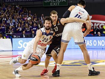 Real-Star Sergio Llull (l.) hat freie Bahn, da der Bamberger Janis Strelnieks am Block von Gustavo Ayon (r.) hängen bleibt. Foto: imago