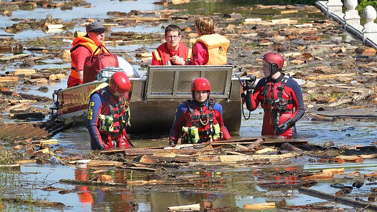 Helfer evakuieren am 05.06.2013 in Deggendorf eine Bewohnerin eines vom Hochwasser eingeschlossenen Hauses. Foto: dpa