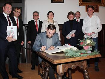 Michael Stadelmann, Sebastian Thiem, Johannes Wenzel und Andreas Rösch (v.l.) schreiben  ins goldene Buch. Mit im Bild: Harry Weiß, Georg Löffler und Robert Porzelt  (Sparkasse) sowie  Angela Hofmann. Foto: Andreas Schmitt