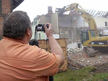 Ein großer Moment, die Abrissarbeiten am "Stehli-Haus" in Ahorn haben begonnen - das  muss  Mario Stadelmann von der Gemeindeverwaltung natürlich dokumentieren. Foto: Berthold Köhler