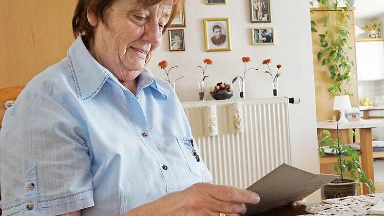 Christel Harmgarth blättert in ihrem DDR-Facharbeiterbrief, den sie aufgehoben hat. Fotos: Arkadius Guzy