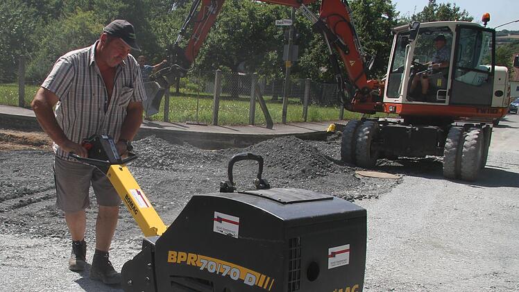 Jürgen Korzendörfer (53) schiebt auf einer Baustelle in Stadtsteinach die Rüttelmaschine vor sich her. Dicke Staubwolken hüllen ihn ein. Der Schweiß rinnt ihm über die Stirn, trotzdem behält er Oberhemd an und Mütze auf. Außerdem trinkt er pro Tag zwischen 3,5 und fünf Liter Wasser.  Foto: Sonny Adam