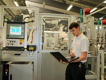 Bei Brose kann Nicolas Schönmüller sein handwerkliches Geschick mit seiner Begeisterung fürs Programmieren verbinden. Seine Prüfung zum Elektroniker für Automatisierungstechnik legte er mit der Note 1,2 ab und erreichte damit in der Winterprüfung 2016/17 das beste Ergebnis von 302 Absolventen. Fehler auszulesen, wie hier an einer Brose-Kunststoffspritzgussanlage, gehört zu seinen Aufgaben.  Foto: Bettina Knauth