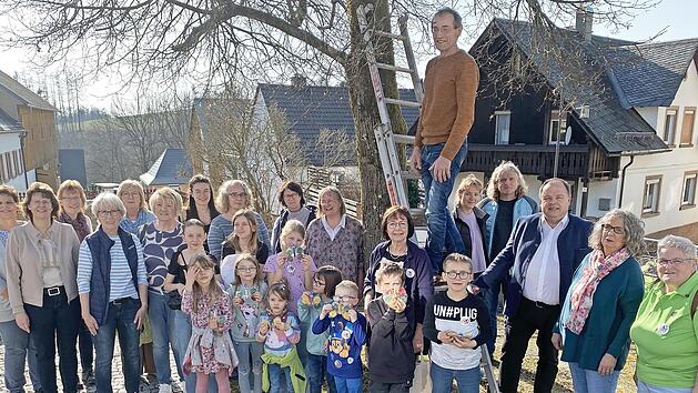 Die Naturkids (im Bild mit den Betreuern und dem Vorstand des Gartenbauvereins) bestehen seit 20 Jahren und hängten daher 20 Nistkästen auf. Im Bild: Vorsitzender Michael Schüssler (auf der Leiter), Bürgermeister Werner Burger (rechts neben der Le...