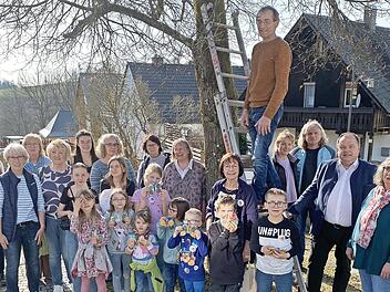 Die Naturkids (im Bild mit den Betreuern und dem Vorstand des Gartenbauvereins) bestehen seit 20 Jahren und hängten daher 20 Nistkästen auf. Im Bild: Vorsitzender Michael Schüssler (auf der Leiter), Bürgermeister Werner Burger (rechts neben der Le...