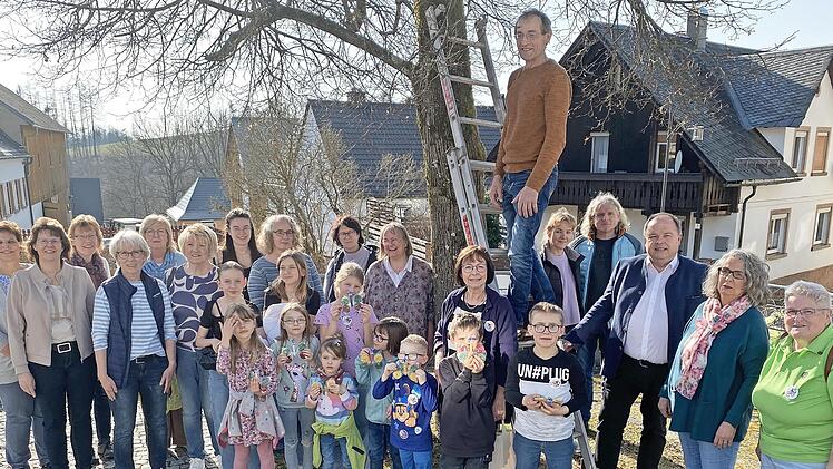 Die Naturkids (im Bild mit den Betreuern und dem Vorstand des Gartenbauvereins) bestehen seit 20 Jahren und hängten daher 20 Nistkästen auf. Im Bild: Vorsitzender Michael Schüssler (auf der Leiter), Bürgermeister Werner Burger (rechts neben der Le...