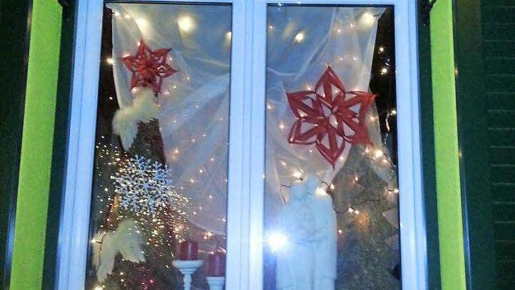 Eines der Adventsfenster mit Kerzen und Sternen. Fotos: Stefan Geiger