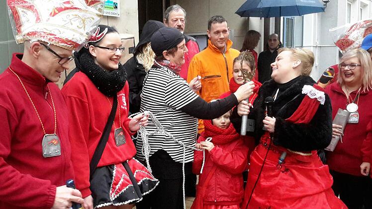 Für diesen Moment haben Aktive und Zuschauer trotz strömenden Regens lange ausgeharrt: Bad Brückenaus Bürgermeisterin Brigitte Meyerdierks übergibt den symbolischen Rathausschlüssel an die Faschingsprinzessin Katharina II. Foto: Rolf Pralle