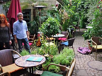 Üppiges Grün, mächtige Kirschbäume und plätscherndes Wasser verbreiten im Garten Café Karibik Urlaubsstimmung. Mit im Bild: Ulrike Bernardt und Martin Ludwig. Foto: Gerd Fleischmann