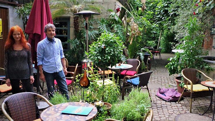 Üppiges Grün, mächtige Kirschbäume und plätscherndes Wasser verbreiten im Garten Café Karibik Urlaubsstimmung. Mit im Bild: Ulrike Bernardt und Martin Ludwig. Foto: Gerd Fleischmann
