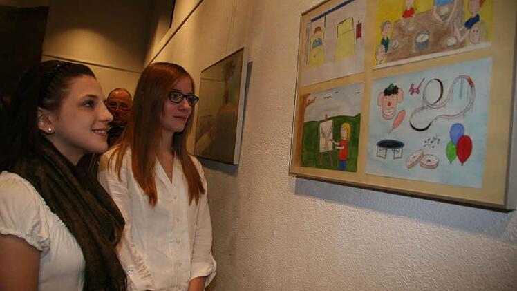 Michelle Höfner und Eva Müller schauen sich noch einmal die Originalzeichnungen an. Sie kommen im Buch bestens heraus, sind sogar noch leuchtender und freundlicher.