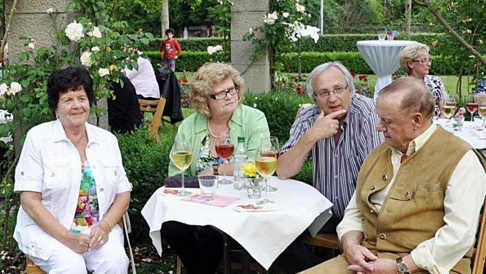 Der Rosengarten in der Promenade in Ha&szlig;furt bot eine stimmungsvolle Atmosph&auml;re f&uuml;r das Konzert am Wochenende. Die Besucher, hier die Familien Br&uuml;ckner und Krieger,  genossen die Darbietungen im Freien. Foto: ul