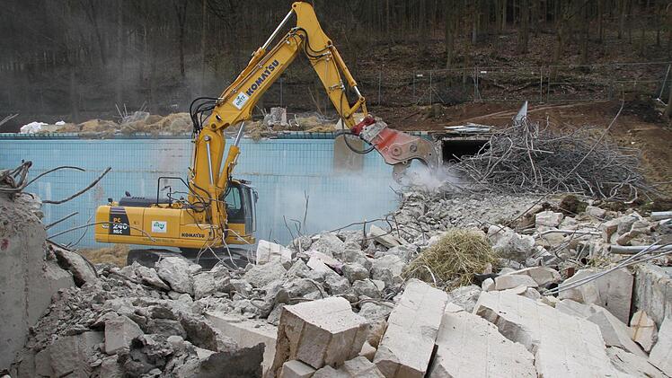Der Bagger ist im Einsatz. Nach der Sprengung des Zehn-Meter-Turms wird das Sprungbecken abgerissen. Foto: Alexander Hartmann