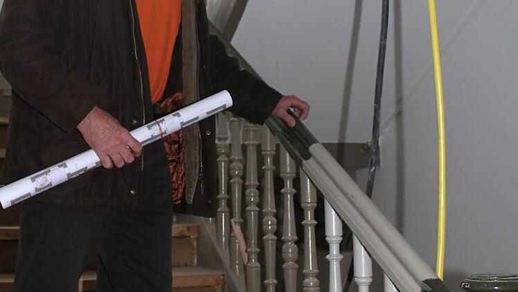 Architekt Peter Schickel zeigt die neue Farbgestaltung des Treppengeländers: Es wird in Grautönen gestrichen. Auch der Stufenbelag wird erneuert.