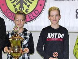 Aus der Hand des Vorsitzenden Ralf Pratsch nahm Hannes Kolb den überdimensionalen Tim-Hempfling-Gedächtnispokal entgegen. Neben dem Jugendclubmeister die Nächstplatzierten Luca und Lenny Luther.  Fotos: Klaus Oelzner