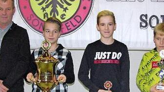 Aus der Hand des Vorsitzenden Ralf Pratsch nahm Hannes Kolb den überdimensionalen Tim-Hempfling-Gedächtnispokal entgegen. Neben dem Jugendclubmeister die Nächstplatzierten Luca und Lenny Luther.  Fotos: Klaus Oelzner