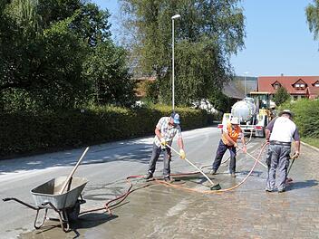Zu den ersten Arbeiten an der Ortsdurchfahrt in Ködnitz gehörte das Einbringen frischer Zementschlämme in die aus Natursteinpflaster gestalteten Entwässerungsrinnen. Foto: Werner Reißaus