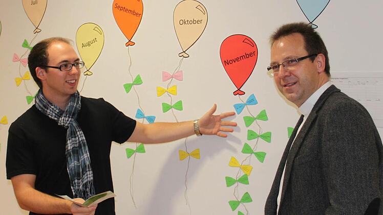 Der neue Jugendreferent Stephan Noppenberger (links) zeigt dem Dekanatsjugendseelsorger Burkhard Farrenkopf das Jahresprogramm, das in dieser Form im Höchstadter Büro hängt.  Foto: Andreas Dorsch