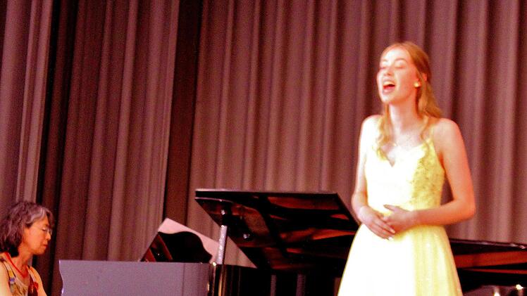 Magdalena Keller im weitschwingenden gelben Glitzerkleid mit Pianistin Keiko Meißner. Sie bricht den Bann mit Schumanns "Der Nussbaum".
