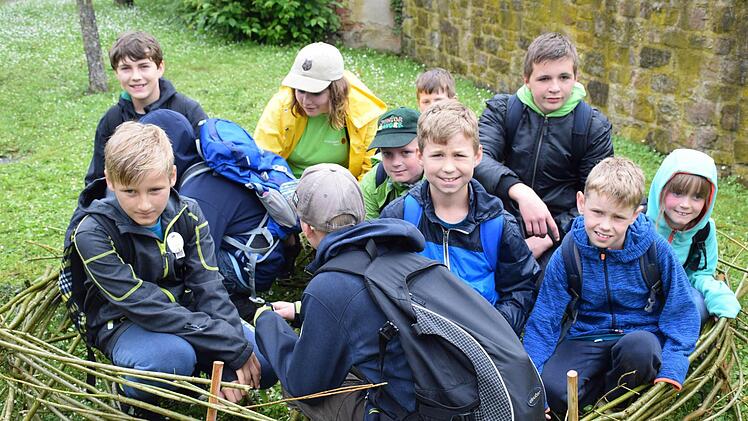 Junior Ranger hocken in Hammelburg in einem nachgebauten Storchennest aus Weidenzweigen. Foto: Ulrike Schade