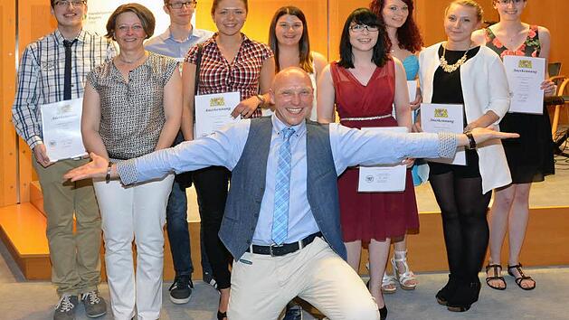 Hier strahlen sie um die Wette - acht Kaufleute im Einzelhandel, bzw. Verk&auml;uferin/Verk&auml;ufer haben beim Berufsschulabschluss mit einem Notendurchschnitt von unter 1,5 abgeschlossen. Auf unserem Foto v.li.: Timo Manger, Berufsschulleiterin Karin Maywald,Troy Davis, Angelique Schreiner, Sarah Kornmann, Kristin Markmann, Angelina Wei&szlig;, Jaqueline Zeps und Louisa Roth. Im Vordergrund Unterfrankes Bezirksvorsitzender des Bayerischen Handelsverbandes Ralf Ludewig.  Foto: Peter Rauch