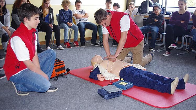 Schulsanitäter Tobias demonstriert, wie der Defibrillator eingesetzt wird.  Foto: Heike Schülein