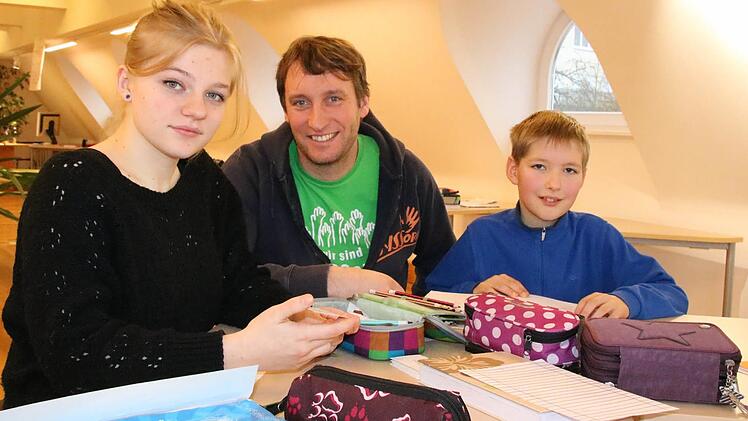 Schulleiter Bernhard Löser (Mitte) geht mit den Schülern Lara Hofmann aus Bad Kissingen und Lorenz Ammersbach aus Garitz den aktuellen Lernstoff und die Eintragungen ins Lerntagebuch. Foto: Ralf Ruppert