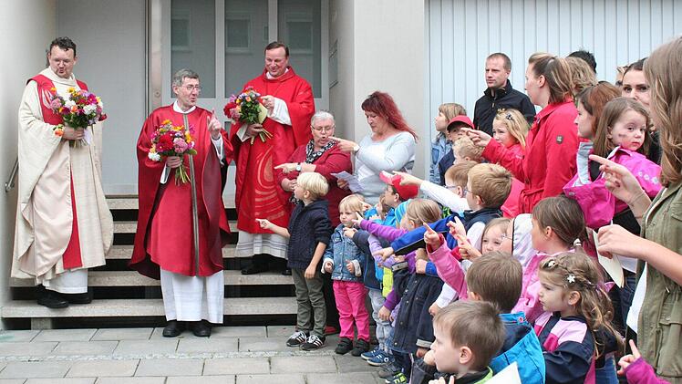 "Ein Volltreffer Gottes bist du" sangen die Kindergartenkinder für die beiden Seelsorger Pater Stephan Panzer und Pfarrer Wolfgang Schmidt (von links). Rechts auf der Treppe Dekan Albert Müller, der die beiden ins Amt einführte.