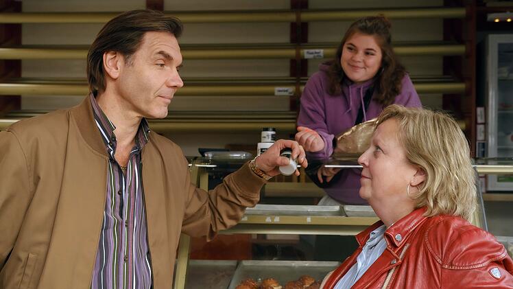 Tina (Gabriele Maria Schmeide, rechts) und Caro (Runa Greinger) müssen bei Bäcker Kowalski (Max Hopp) Überzeugungsarbeit leisten.