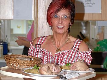 Lizi Maier serviert Schweinshaxen - ein freundliches Lächeln für die Gäste der Willmersreuther "Krumba" gibt es gratis. Foto: Karl Klippel