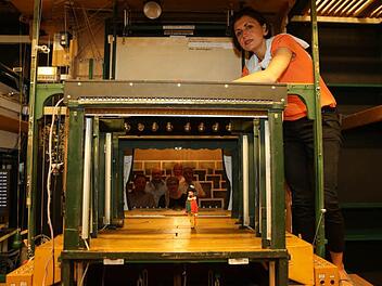 Der ungewöhnlicher Blick durch die Kulissen zeigt die winzige Bühne des Bamberger Marionettentheaters mit dessen Leiterin Maria Sebald. Im Hintergrund sind einige Zuschauer zu erkennen. Foto: Barbara Herbst