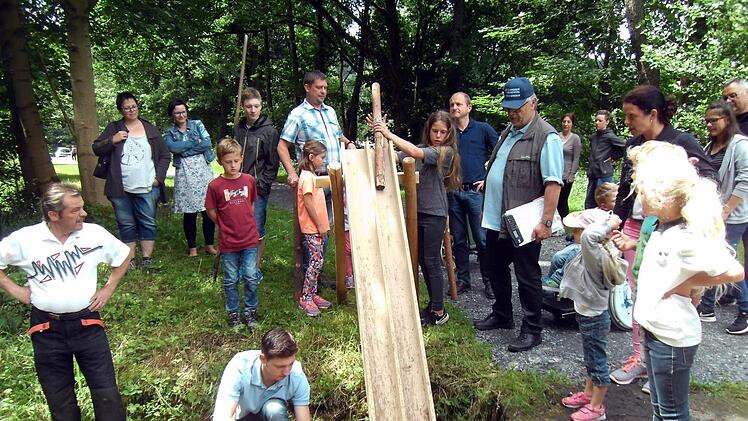 Über eine Rutsche wurde das "Blöchla" von den Kindern zu Wasser gelassen. Michael Kestel (mit Mütze) passt auf, Felix Neder (kniend) bringt die Blöchla in die richtige Position. Foto: Susanne Deuerling