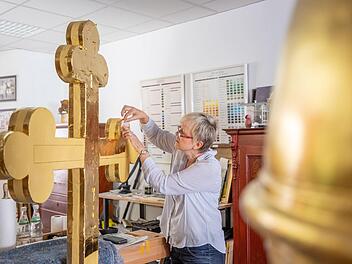 600 Blatt Blattgold benötigte Petra Zenkel-Schirmer, um das Kreuz und die Kugel neu zu vergolden. Foto: Marian Hamacher