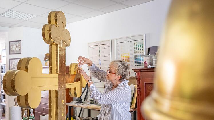 600 Blatt Blattgold benötigte Petra Zenkel-Schirmer, um das Kreuz und die Kugel neu zu vergolden. Foto: Marian Hamacher
