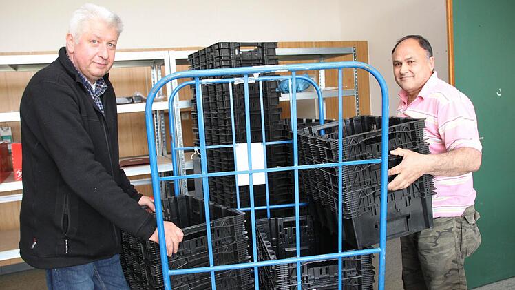 Pedzet Aziri (rechts) hilft Hermann Fella beim Stapeln der Kisten für die Essensausgabe. Zweimal pro Woche wird das Heim von einem Caterer aus Nürnberg beliefert, der die von den Bewohnern bestellten Sachen in die Gemeinschaftsunterkunft bringt.  Fotos: Markus Reeh