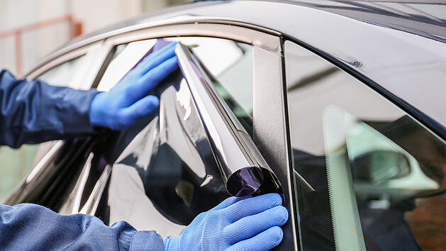 M&auml;nnlicher Arbeiter, der Autoscheiben t&ouml;nt