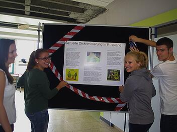 Sozialkundelehrerin Franziska Gröger betrachtet die Stellwand, die von Sophia Rubel und Pauline Wittig zum Thema "Sexuelle Diskriminierung" gestaltet wird. Auch Benedict Behner (rechts) hilft mit.  Foto: Heike Schülein