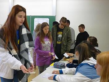 Wie bei der richtigen Wahl zum bayerischen Landtag zeigt Viviane Schwartl vor Aushändigung der identischen Wahlunterlagen für den Stimmkreis Bad Kissingen ihren Personalausweis vor, bevor ihr die Unterlagen ausgehändigt werden. Celina Schmidt, Lukas Götz und Leon Geßner warten noch auf ihre Wahlscheine, Sophie Bäumker (vorne rechts) fungiert als Wahlhelferin. Foto: Manfred Mellenthin
