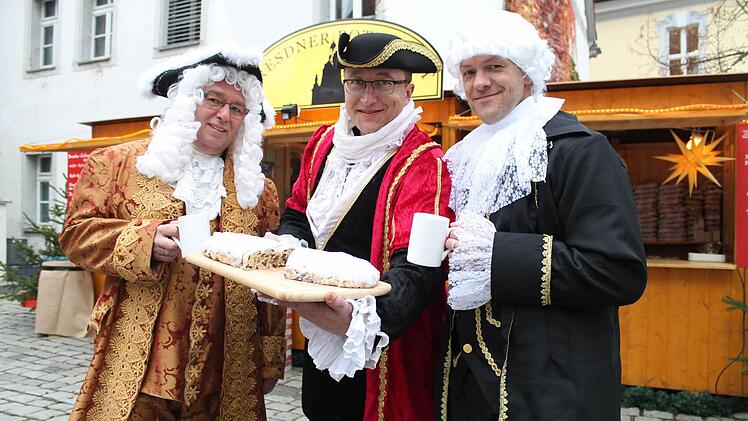 In historischen Kostümen verkaufen Torsten Meisel, Hendrik Dietrich und Dirk Bähr (von links) original Dresdner Striezel (Christstollen), Glühwein, Süßigkeiten und viele andere Leckereien aus der Region um die sächsische Landeshauptstadt. Foto: Thomas Heuchling