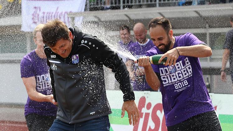 Michael Hutzler führte den FC Eintracht Bamberg auf Anhieb in die Landesliga zurück. Hier erhält der Trainer von Christos Makrigiannis (r.) und Marc Reischmann nach dem Gewinn der Bezirksliga-Meisterschaft eine Sektdusche. Foto: sportpress